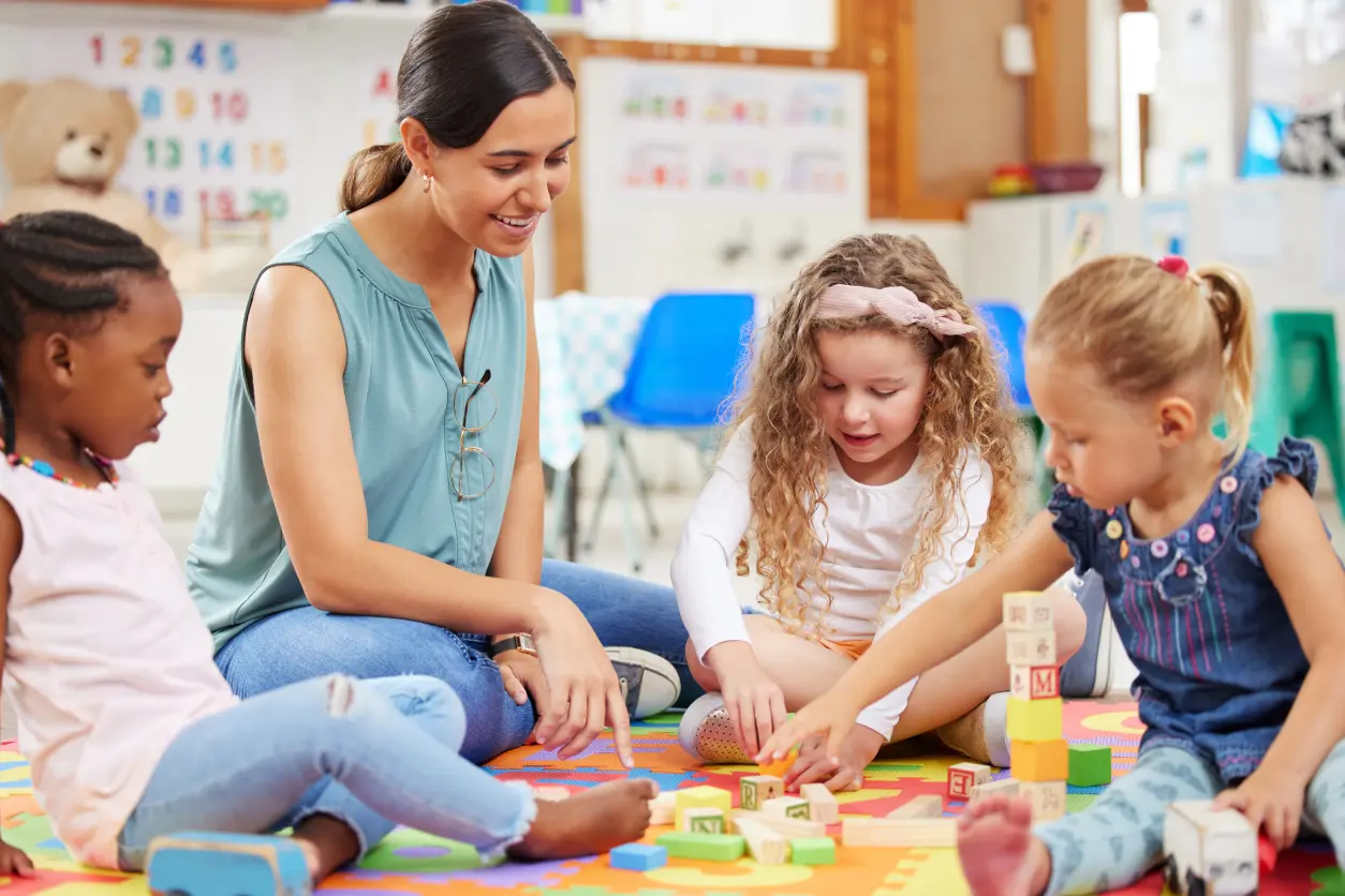 Teacher and kids playing with blocks together.