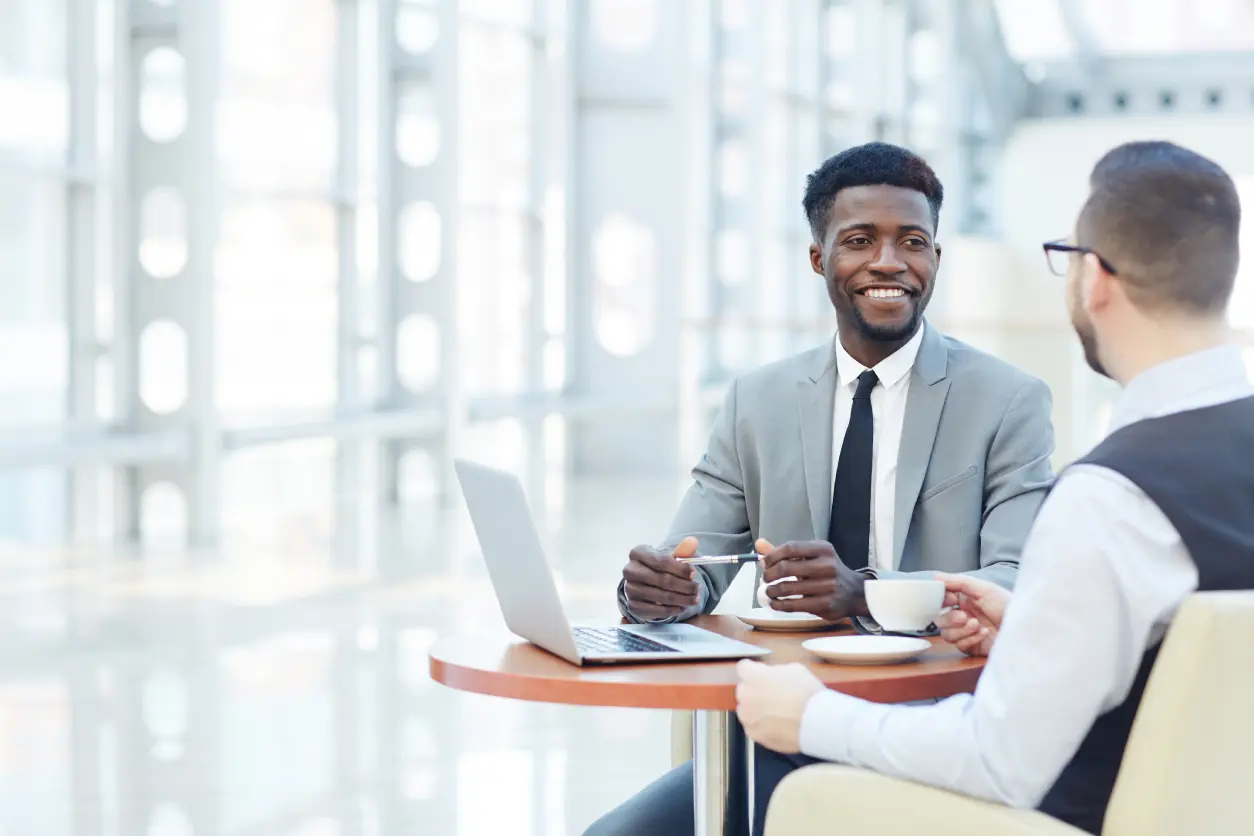 Two businessmen meeting over coffee with laptop