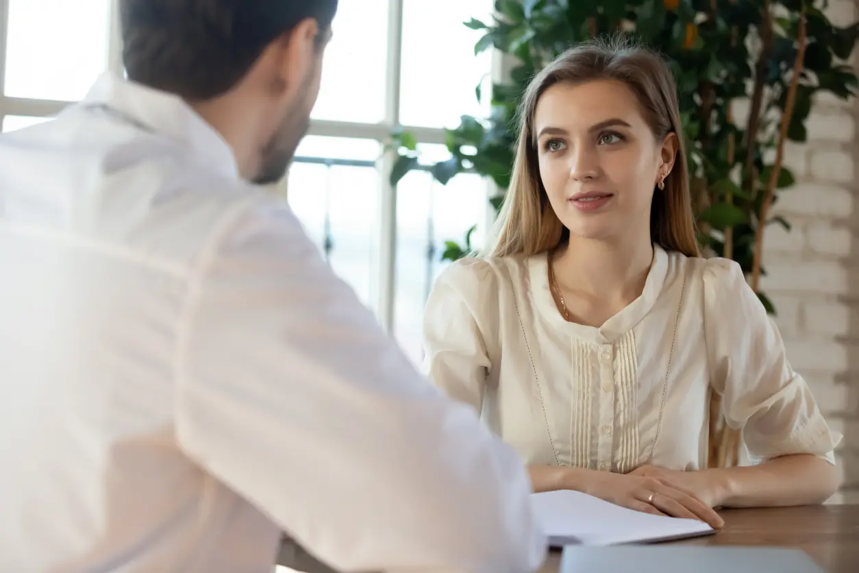 Two people having a conversation at table.